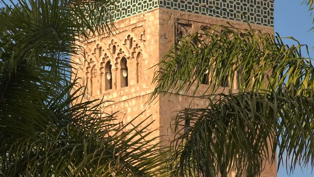 Close-up view of the Koutoubia minaret through a frame of palm trees, in Marrakech

