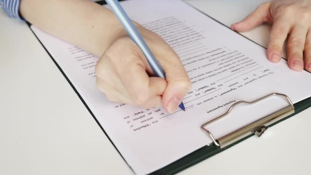Payment agreement, hand fills out a document, debt management, financial planning, contract signing, property purchase