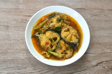 spicy boiled catfish with basil and chili in curry soup on plate 