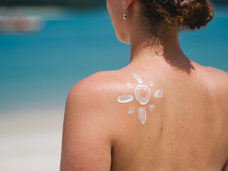 Woman with Sun-Shaped Sunscreen Lotion Shoulder by the Ocean