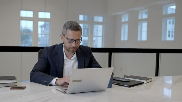 Office worker with laptop at office. Ofice employee remote working in modern office. Businessman have on line meeting. Business man using computer in office. Modern offices workplace.