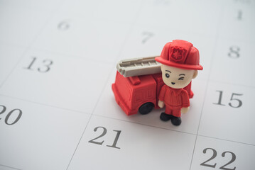 Firefighter and fire truck on calendar background copy space. Concept of fire extinguisher...
