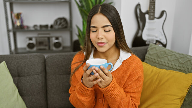 A content young woman enjoying a cup of tea in a cozy living room, evoking warmth and relaxation.