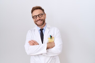 Middle age doctor man with beard wearing white coat happy face smiling with crossed arms looking at...