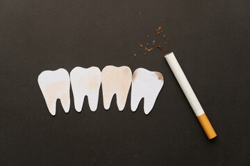 Cigarettes or tobacco with tooth shape on black background. Teeth problems caused by smoking...