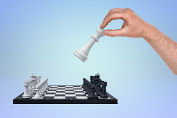 Hand tipping chess king in a strategic move
