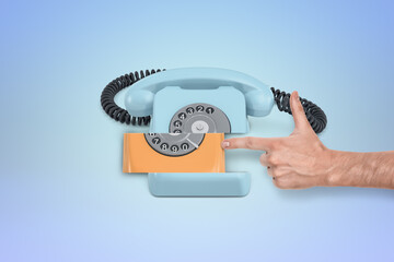Hand dialing a retro orange rotary phone