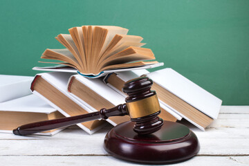Law concept - Open law book, Judge's gavel on table in a courtroom or law enforcement office.