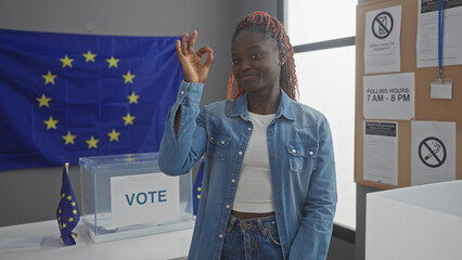 Young black woman showing approval with a hand gesture in a european electoral room with eu flags