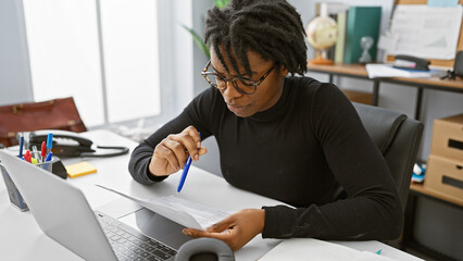 Focused young woman with dreadlocks working on documents in a modern office interior.