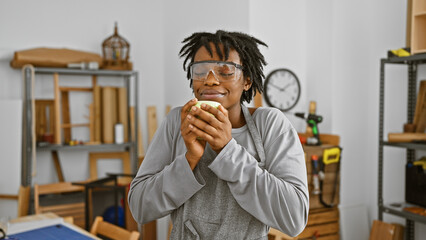 African american woman with dreadlocks enjoying a coffee break in a carpentry workshop