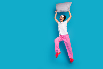 Full body portrait of pretty young woman fly pillow empty space wear pajama isolated on blue color...