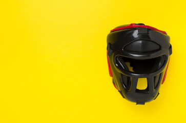 Fototapeta premium Black leather boxing helmet on color background, top view.