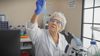 Senior woman scientist examining a test tube in a laboratory, showcasing experience and expertise...