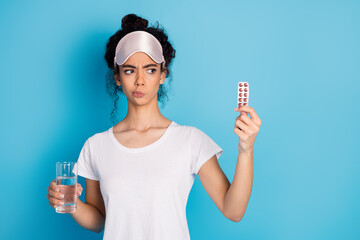 Portrait of pretty young woman pills water empty space wear pajama isolated on blue color background