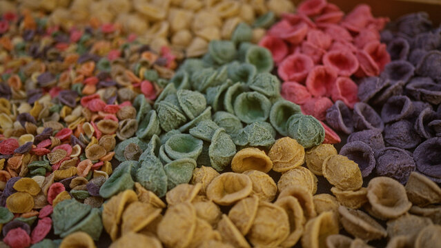 A vibrant display of colorful traditional italian pasta outdoors in bari, puglia, italy, showcasing various hues and textures in a sunny european setting.