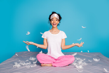 Full body portrait of pretty young woman throw feather wear pajama isolated on blue color background