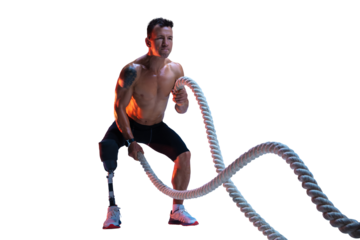 Muscular shirtless man, athlete with prosthetic leg training with battle ropes, demonstrating strength and endurance isolated on transparent background. Inclusive sport, heath care, endurance concept