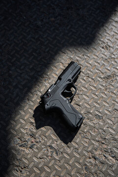 Modern semi-automatic pistol. Armament for the army and police. Short-barreled weapon. Gray concrete background.