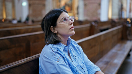 Young beautiful hispanic woman sitting on a church bench at St. Karl BorromÃ¤us church