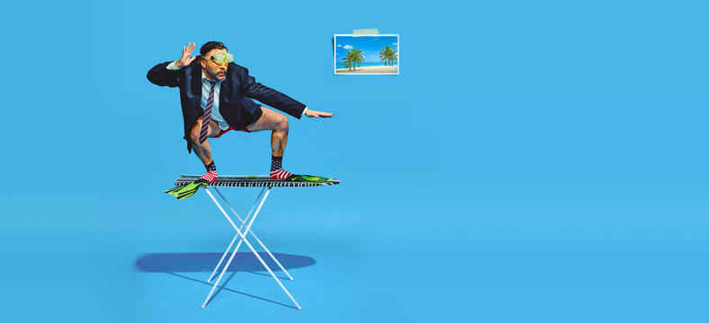 Banner. Man stands on ironing board dressed in half in formal attire and diving mas as if he surfing against blue background. Concept of pop art, remote work, recreation, lifestyle, fashion and style.