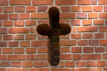 Cross on a brick wall.
