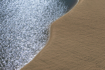 Sandy shore and water, view from above.
