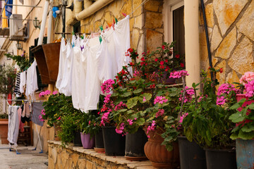typical mediterranean italian, greek, street view, linens drying in streets open air, pot geranium...