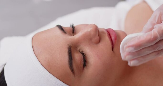 Female lips filler cosmetic process, procedure of lip augmentation, beautiful face close up. Syringe near mouth for injection to increase lips size, shape, to restore, add volume, make fuller, plumper