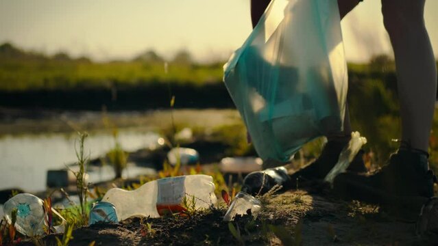 A man sorts plastic bottles and other waste and places it in a garbage bag. By carefully collecting plastic waste, it promotes further recycling and sustainable disposal of disposable tableware
