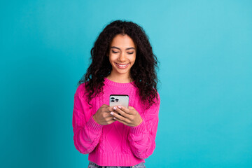 Photo of lovely young girl use smart phone wear pink pullover isolated on teal color background