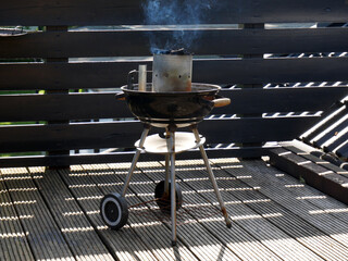 The grill grate in subtle smoke. A summer day on the terrace.