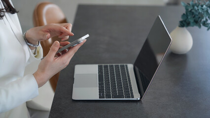 ノートパソコンとスマホを使う女性 © metamorworks