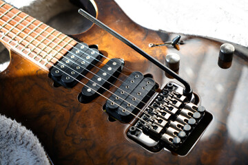 Electric guitar bridge, strings and pickup, detail close-up view of guitar pickup in wood walnut