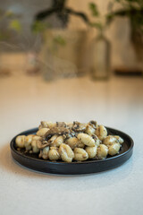potato gnocchi with mushroom sauce, warm gnocchi on black plate, smoke coming out