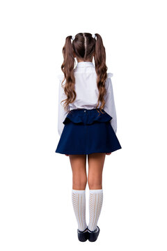 Snap shot rear back view of nice adorable stylish girl with curly pigtails in formal white blouse shirt, short blue skirt, gaiters, shoes. Isolated over grey background