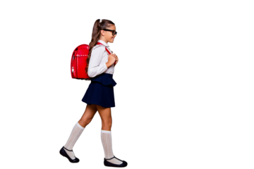 Full size body length profile side view of nice smart cute stylish small girl with curly pigtails in white blouse shirt and blue skirt with red bag, going to school. Isolated over black background