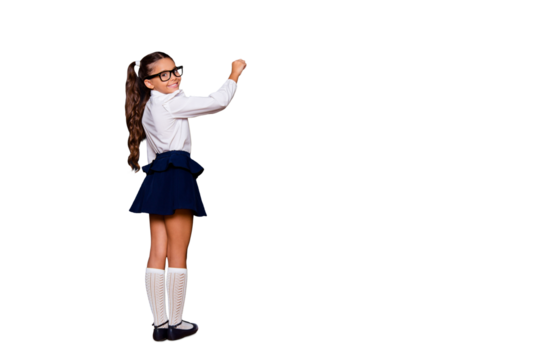 Full size body length of nice genius adorable lovely small little girl with curly pigtails in white formal blouse shirt, blue skirt, writing on blackboard. Isolated over black background