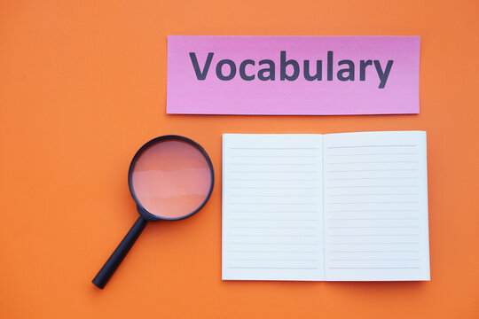 Magnifying glass, paper notebook and vocabulary card. Concept. Education material.Teaching aid. Learning language. Find or search vocabulay in lesson.      