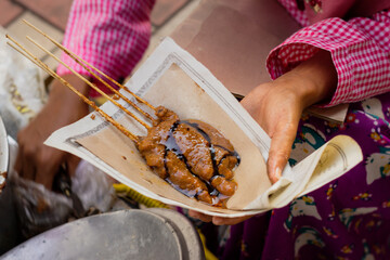 Close up of chicken satay with rice cake or called lontong is preparing by the seller 