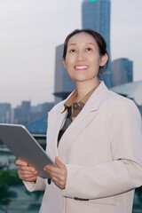 Confident Businesswoman with Tablet in Urban Setting