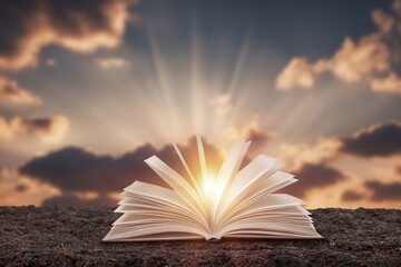 Scriptures on pages open book at bright sunset background