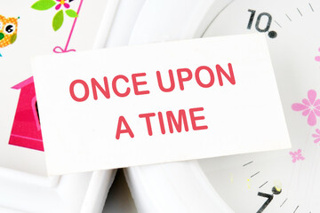 ONCE UPON A TIME text text on the business card on the background of the clock