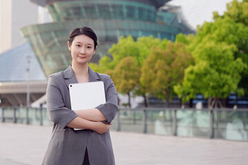 Confident Professional Poses with Tablet Outside Office