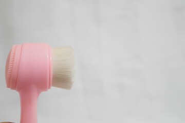 A pink and white brush is shown on a white background