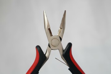 A pair of pliers with a red handle and a black handle