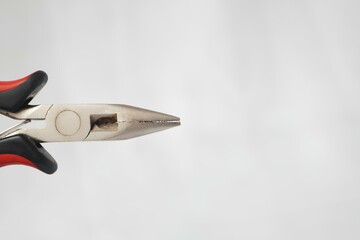 A pair of pliers with a small hole in the middle of the handle