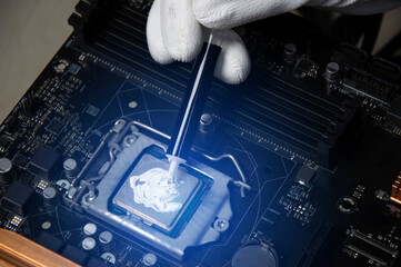The technician is adding thermal silicone to the CPU chip.