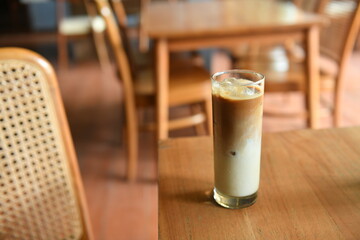 Iced coffee milk with palm sugar on wooden table.