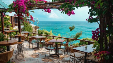 A patio with tables and chairs overlooking the ocean